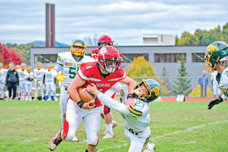 Photo by Calvin Morse.
Nolan Walpole runs over Burr & Burton’s Owen Cassan en route to a Redhawk’s 41-3 home win last Thursday, Oct 10. Champlain Valley closes its regular season at South Burlington this Friday at 7 p.m.