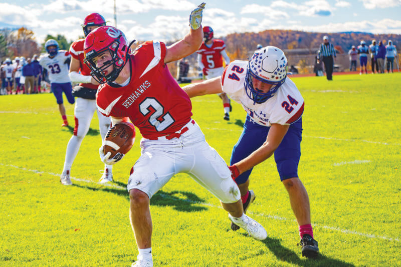 Photo by Calvin Morse Billy Bates eludes Mount Anthony’s Aiden Riordan in CVU’s 63-6 win in the first round of the state playoffs. Bates scored on a 51-yard touchdown pass on the Redhawks’ first play from scrimmage and also had an 80-yard kickoff return.