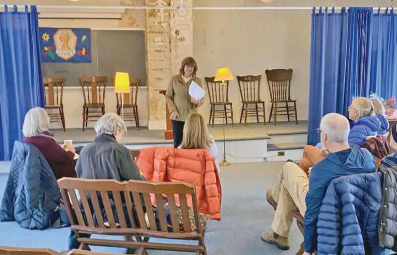 Photo by Sally Wadhams. Grange member Abby Killey welcomes participants to the inaugural Poetry at the Grange event.